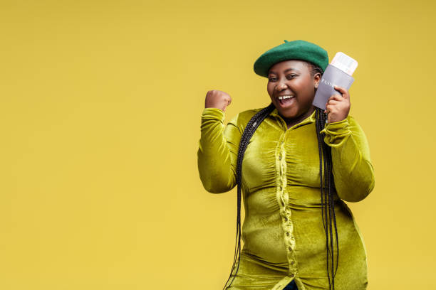 smiling beautiful ethnic african american plus size woman holding passport and board pass - braids african descent women pensive imagens e fotografias de stock