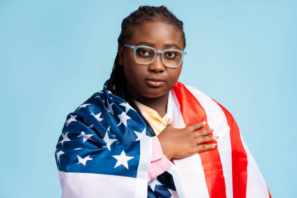 pensive attractive african american woman, patriot wearing eyeglasses, holding american flag - braids african descent women pensive imagens e fotografias de stock