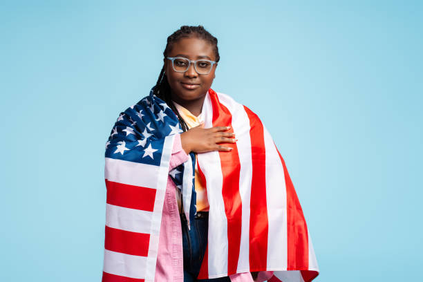 portrait serious beautiful african american woman, patriot wearing eyeglasses, holding american flag - braids african descent women pensive imagens e fotografias de stock