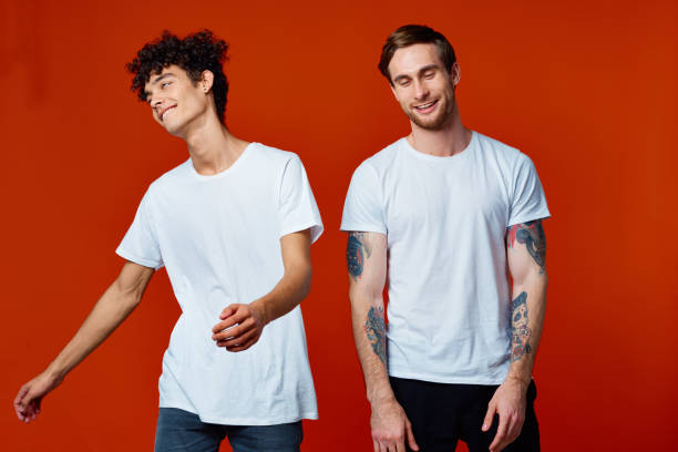 istock Two cheerful friends in t-shirts communicating emotions red background 2053963909