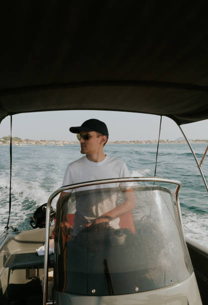 istock A young guy controls a boat on the sea. 2053972340