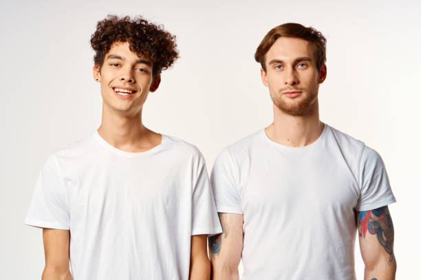 istock Two cheerful friends in white t-shirts emotions studio 2053973399