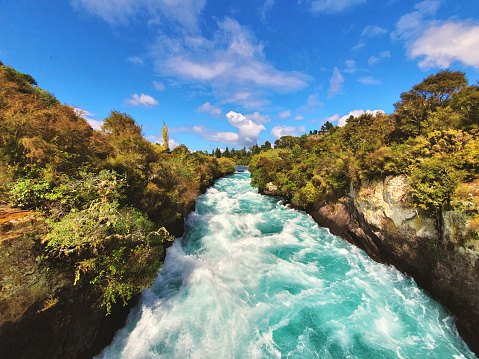 Experience the powerful beauty of Huka Falls in New Zealand. This iconic waterfall showcases the scenic turquoise river amidst stunning natural landscape, perfect for adventure seekers and travelers.