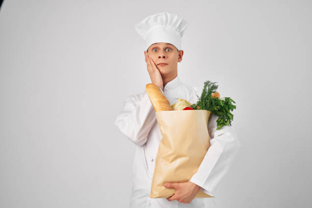 istock cheerful male chef with a package of products working in the kitchen 2054005402