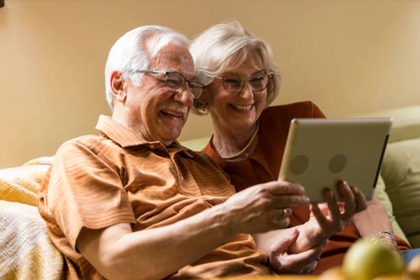 istock Senior couple lounging on sofa and using digital tablet 2054096512