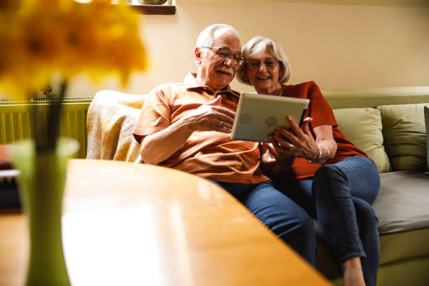istock Senior couple lounging on sofa and using digital tablet 2054097025