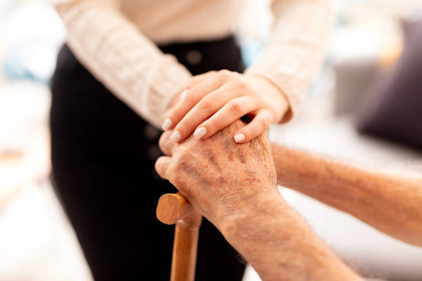 istock Nurse assisting senior with walking cane 2054115630