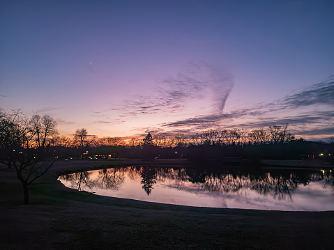Sunset over the pond at the Northfield Hills Condo association at the corner of Long Lake Road and Coolidge Highway in Troy, Michigan, a suburb of Detroit partly cloudy winter day