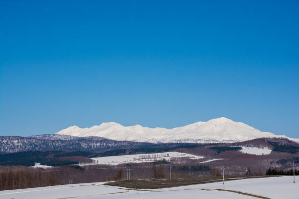 istock Upland field where snow remains and snowy mountains 2054172386