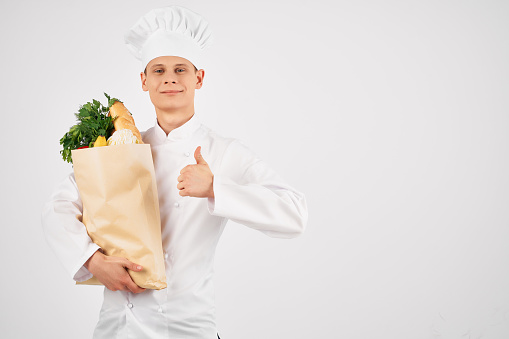 a man in a chef's uniform with a package of products restaurant kitchen service. High quality photo