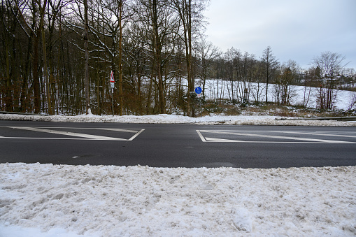 Street crossing for pedestrians and cyclists in winter covered by snow with the road perfectly cleared of snow.
