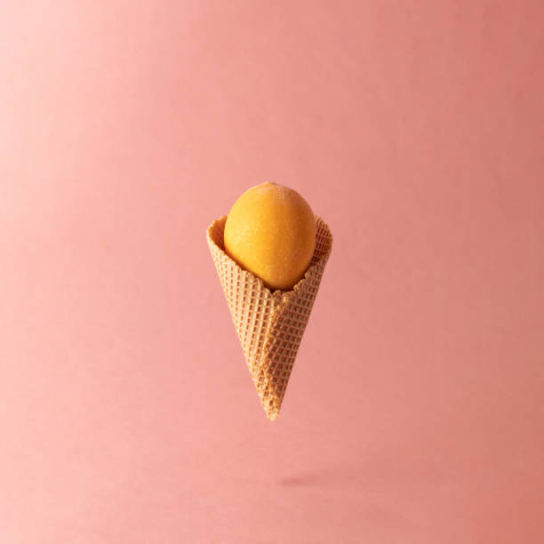 istock Frozen lemon in ice cream cone on pink pastel background. Fruit creative concept. 2054276579