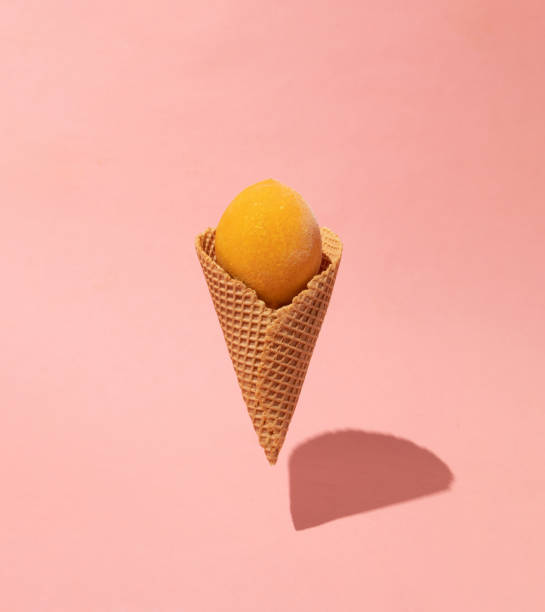 istock Frozen lemon in ice cream cone on pink pastel background. Fruit creative concept. 2054277094