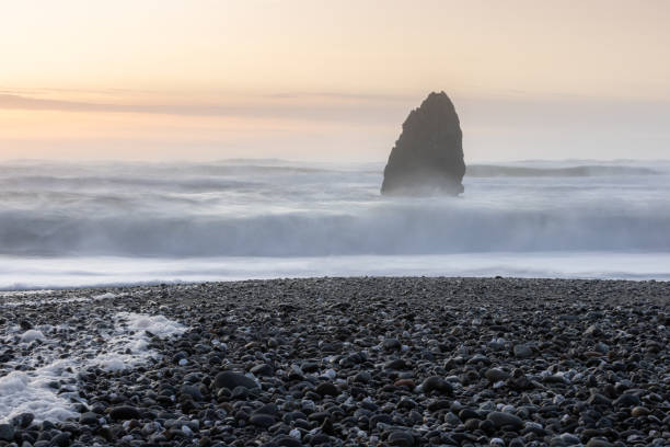 istock A rocky beach with a large rock in the foreground 2054345194
