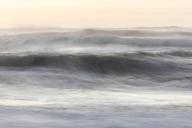 istock The image is a blurry shot of a wave crashing on a beach 2054345706