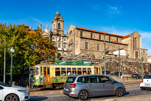 Porto, Portugal - October 6, 2023: Tourists are riding the tram. The street view of Rua do Infante D. Henrique and Church of Saint Francis, Porto, Portugal.