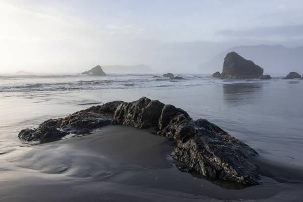 istock A rocky beach with a large rock in the foreground 2054369359