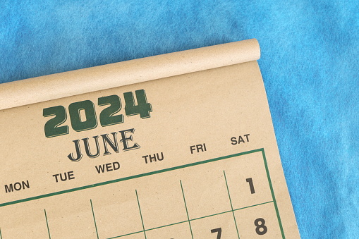 June 2024 calendar flat lay in blue background with copy space.