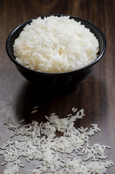 istock Rice in cup on wooden table blurred 2054562933