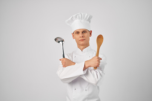 cook with a ladle and a wooden spoon in hands kitchen work. High quality photo