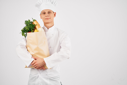 a man in a chef's uniform with a package of products gesturing with his hand healthy food kitchen. High quality photo