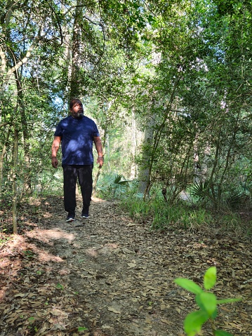 Mature Black Male Walking On Path In A Forest