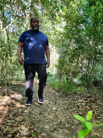 Mature Black Male Walking On Path In A Forest