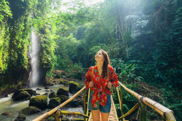 Woman walking near the refreshing waterfall on Bali
