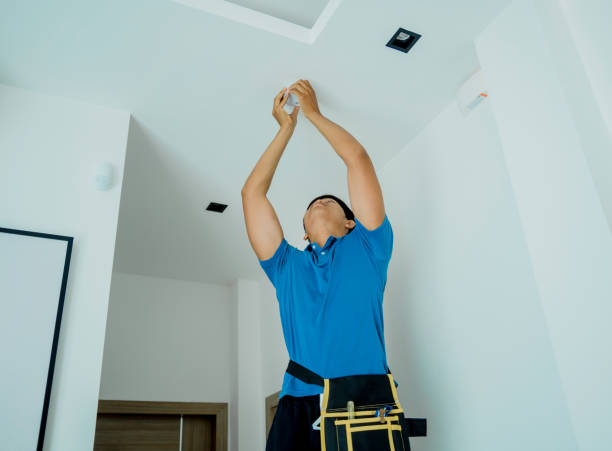 istock Technician installing fire safety detector in a modern apartment 2054702232