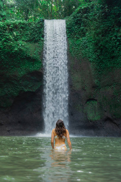 istock Woman swimming in the waterfall on Bali 2054712077