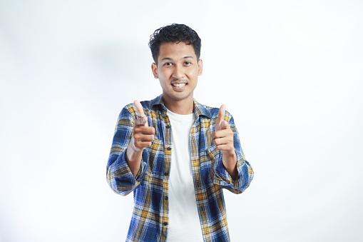 Asian man looking and pointing to camera with enthusiastic expression