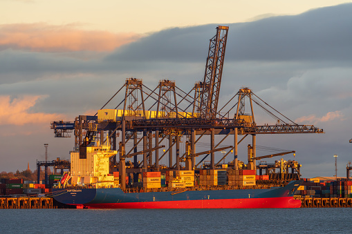 Shotley Gate, Suffolk, England, UK - November 22, 2022: View across the River Orwell to a cargo ship at Felixstowe Harbour