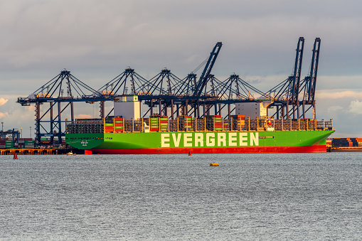 Shotley Gate, Suffolk, England, UK - November 22, 2022: View across the River Orwell to a cargo ship at Felixstowe Harbour