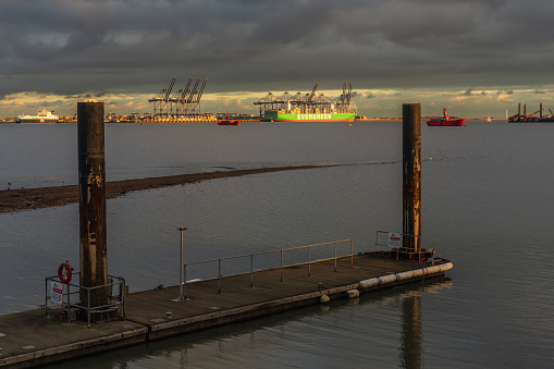 Shotley Gate, Suffolk, England, UK - November 22, 2022: View across the River Orwell to a cargo ship at Felixstowe Harbour