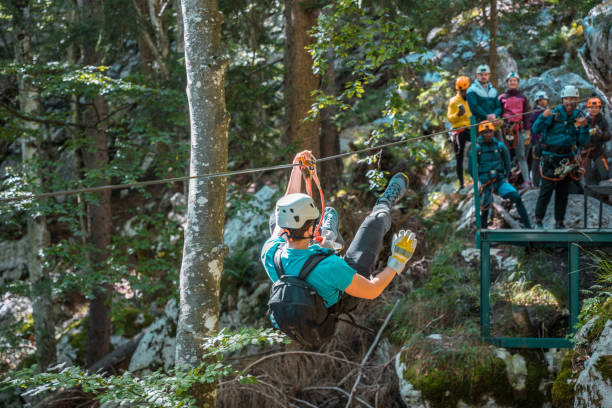 istock Instructor Demonstrating An Exhilarating Ziplining Adventure Amidst Dense Woodland In Front Of A Multiracial Group 2054801086
