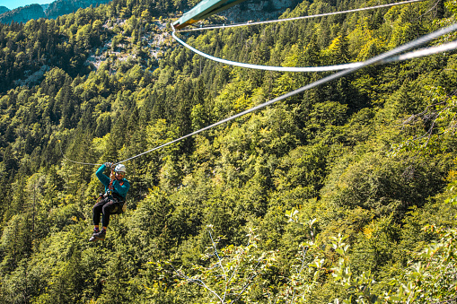 Happy caucasian male gliding through the mountainous terrain on an adrenaline-charged zip-line journey where the fusion of speed height and nature creates an unforgettable outdoor spectacle.