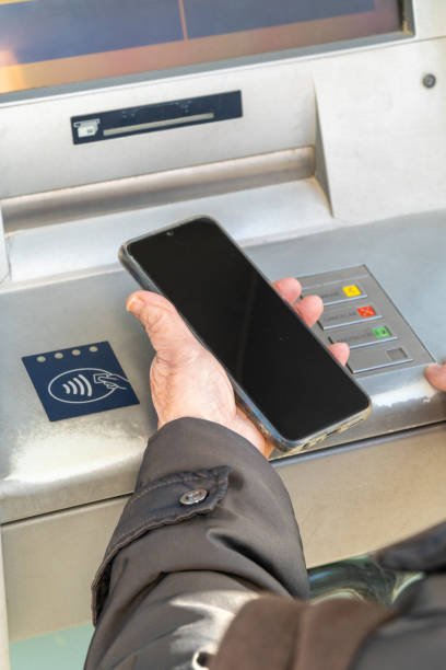 istock Older woman using phone contact less atm 2054808878