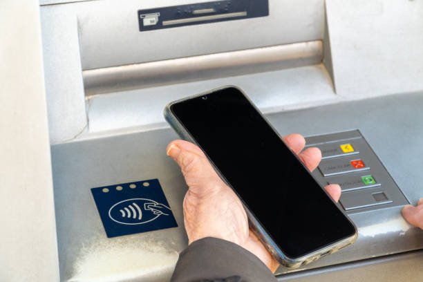 istock Older woman using phone contact less atm 2054808885
