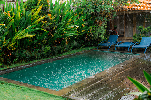 Swimming pool  during the tropical rain in abundant greenery