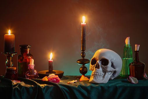 scull and burning candles with halloween decor on dark background