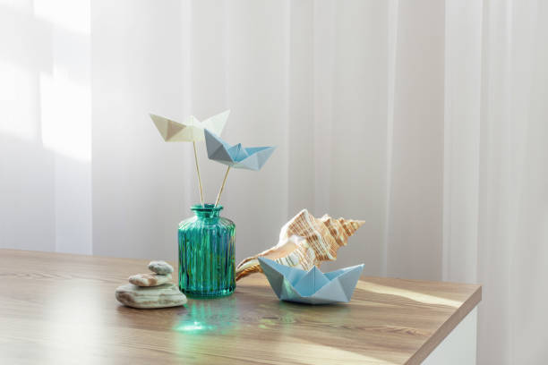 paper boats in glass vase with sea decor on wooden table - nautical vessel isolated toy boat wood fotografías e imágenes de stock