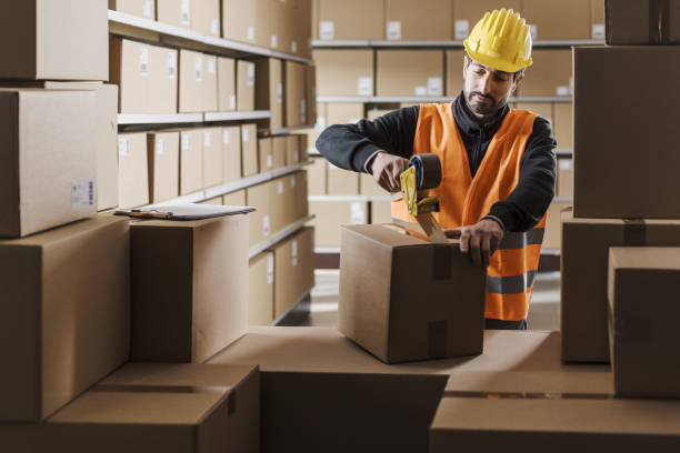 istock Warehouse worker sealing a box with tape 2054902346