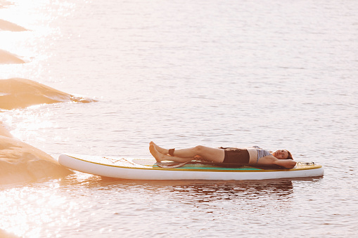 One mid adult woman relaxing at paddleboard