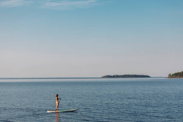 One mid adult man enjoying stand up paddle boarding early in the morning in a tropical area