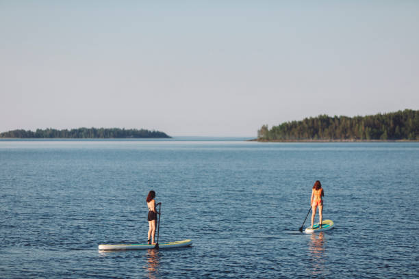 istock Friends paddleboarding at the lake 2054926422