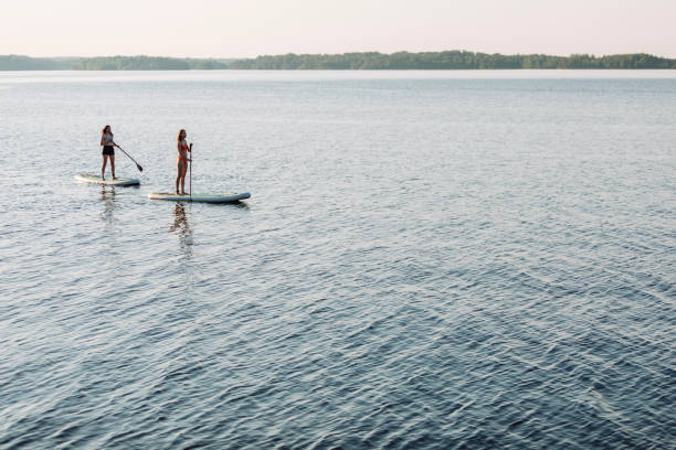 istock Friends paddleboarding at the lake 2054926935