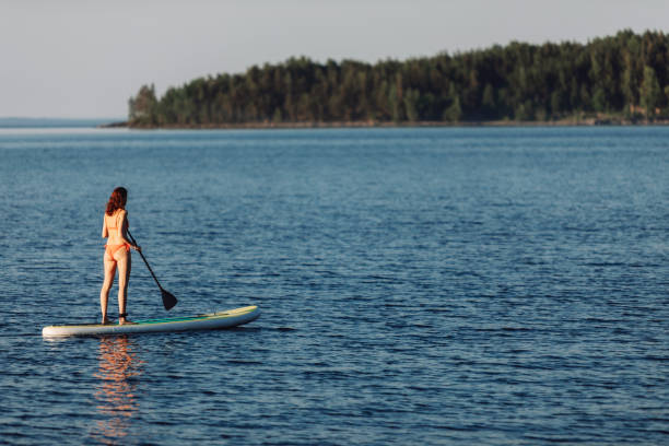 istock One woman paddleboarding at the lake 2054927960