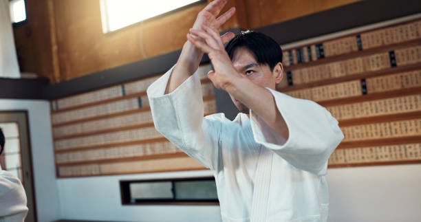 istock Man, martial arts and training aikido in dojo or self defence wellness, practice or combat sports. Male person, gee uniform and hands or Japanese exercise for battle challenge, fitness or fight power 2054929033