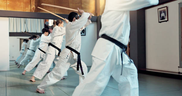 istock Martial arts, aikido class and people with training discipline, self defense and practice sword technique. Black belt students, Japanese group and learning skills development for protection in dojo 2054929598