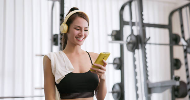 istock female smartphone headset at gym 2054945241